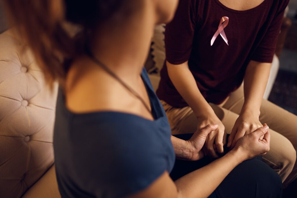 Close-up of woman supporting her friend with breast cancer at home.